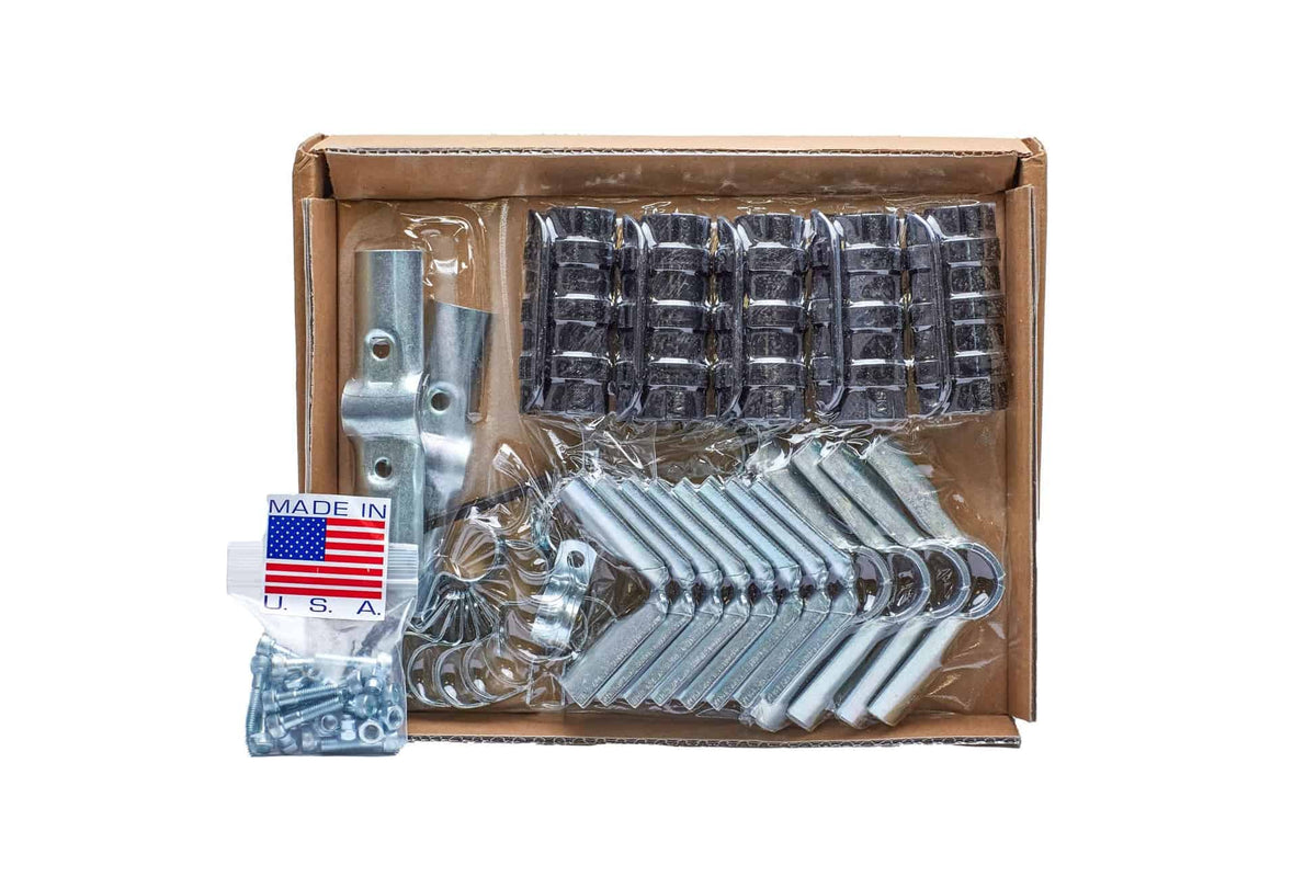 Open cardboard box containing an Epic Cover Frame Kit's hardware: bundled black plastic clamps, angled zinc-plated corner brackets, a metal joint connector, a coiled spring, and a bagged set of nuts and bolts with a "Made in U.S.A." label.