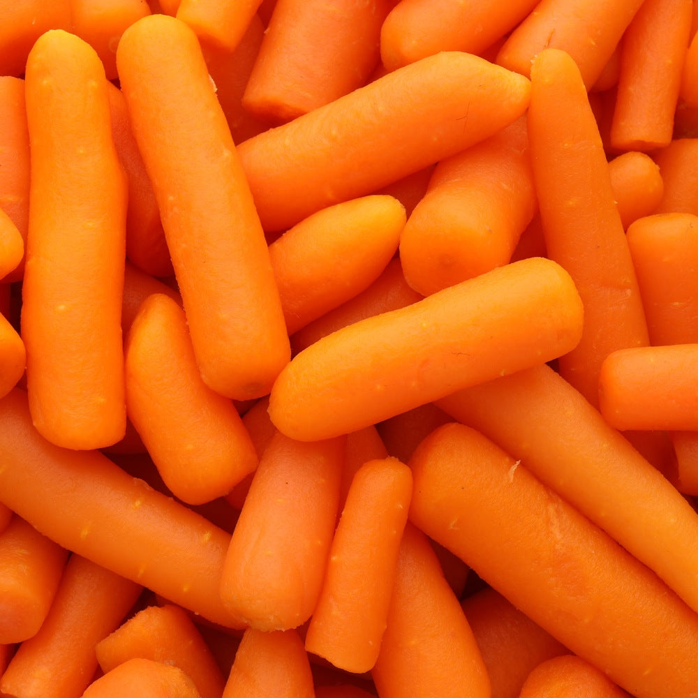 Close-up of peeled baby carrots piled together, their smooth orange skins and rounded, tapered tips filling the entire frame.