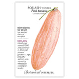 Botanical Interests seed packet for Pink Banana Winter Squash featuring an illustration of a long, tapered salmon-pink squash with a curled green stem, alongside printed text noting it's heirloom, frost sensitive, matures in 100–120 days, and dates to around 1900.