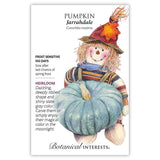 Seed packet for Jarrahdale heirloom pumpkin, illustrated with a straw-hatted scarecrow holding a deeply ribbed, slate-gray pumpkin, with text noting it's frost sensitive, 100 days to maturity, and sown after the last spring frost.