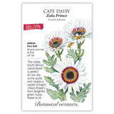 Botanical Interests seed packet for Zulu Prince Cape Daisy, illustrated with white daisy-like blooms featuring maroon and orange centers, gray-green foliage, and a visiting bee, alongside text noting it's an annual for full sun, blooming summer to frost, growing 24 inches tall.