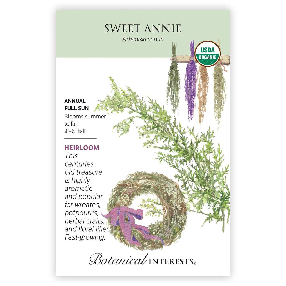 Seed packet for Sweet Annie (Artemisia annua) featuring an illustration of feathery green foliage, a dried herb wreath tied with a purple ribbon, and hanging bundles of dried flowers, with text noting it's an heirloom annual for full sun, 4'–6' tall, blooming summer to fall and prized for wreaths and crafts.