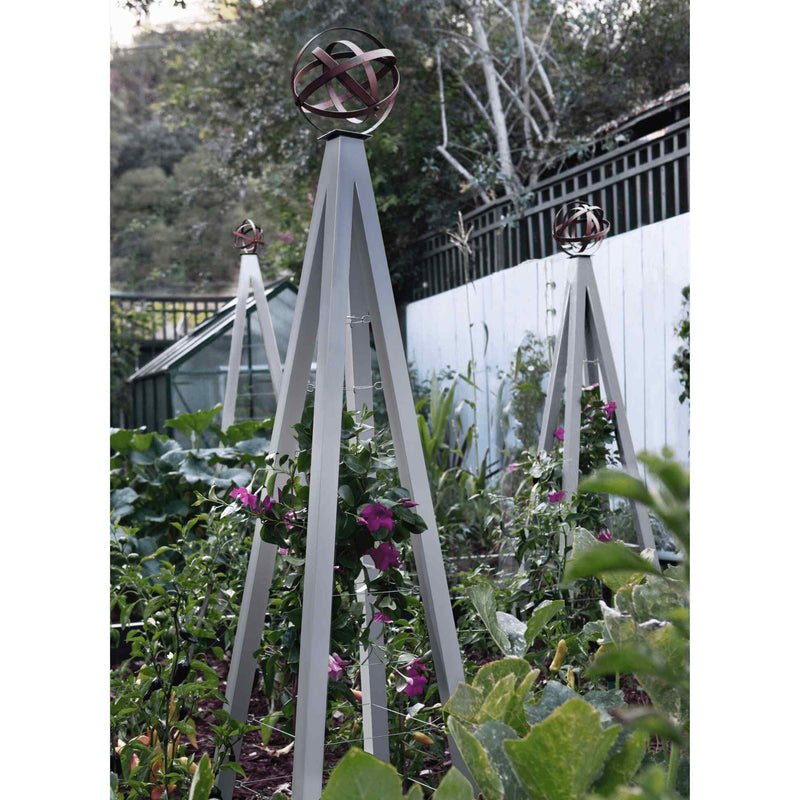 Zinc pyramid-shaped metal Akoris Garden Obelisk Large trellises with bronze sphere finials set among lush green foliage and purple flowering plants