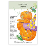 Seed packet for organic Howden pumpkin featuring an illustration of three round orange pumpkins, one carved into a jack-o'-lantern wearing a purple star-patterned witch hat, with text noting 110-day, frost-sensitive growing and its ideal carving qualities.
