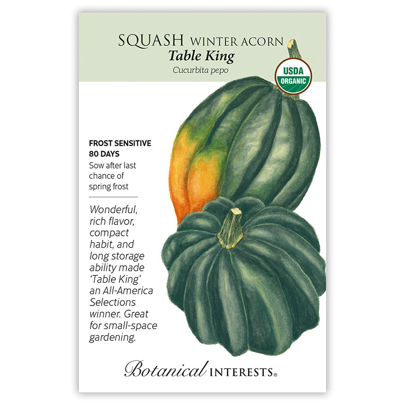 Seed packet for Table King organic winter acorn squash, illustrated with two dark green ribbed acorn squash, one with an orange-streaked side, plus text noting it's frost sensitive, matures in 80 days, and praised for rich flavor and compact habit.