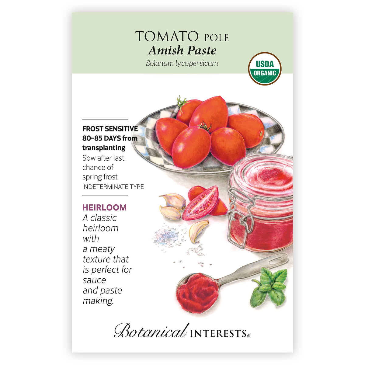 Seed packet for Tomato Pole Amish Paste by Botanical Interests, featuring a white and pale green label with text, a photo of red tomatoes, garlic, basil, and a glass jar of red paste, a USDA Organic seal, and botanical infomation.