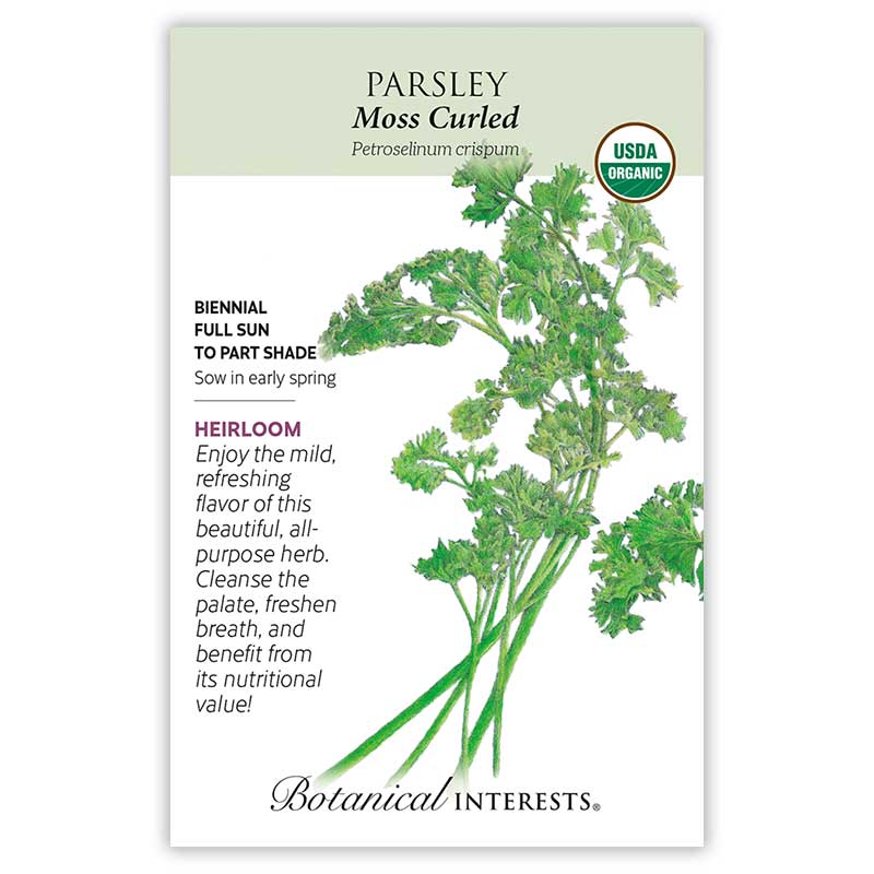 Seed packet for organic heirloom Moss Curled Parsley, featuring an illustration of tightly ruffled, bright green curled leaves on slender stems, with text noting it's a biennial for full sun to part shade, sown in early spring.