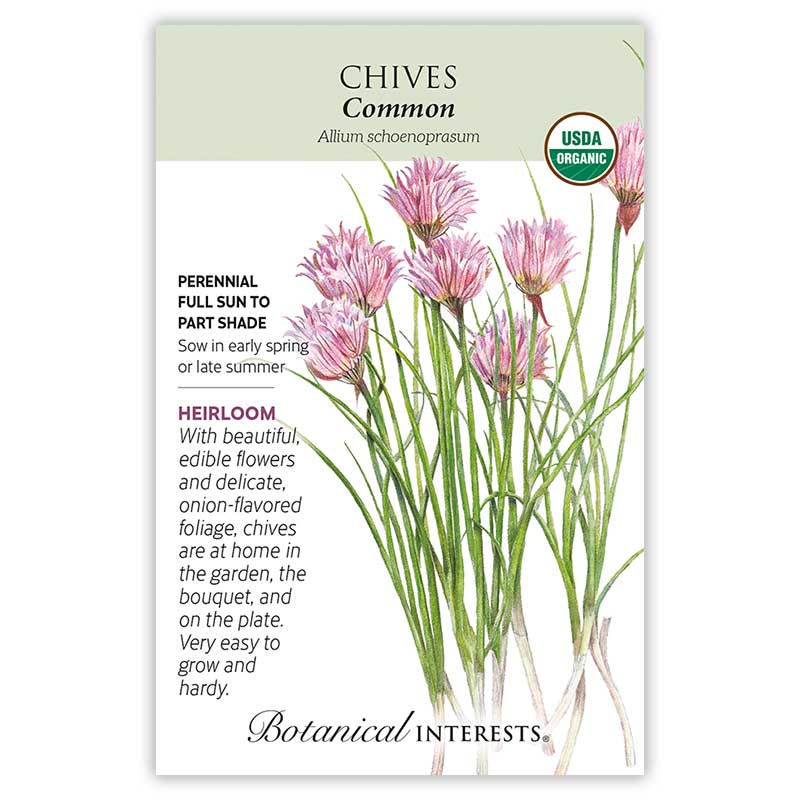 Seed packet for Common Chives (Allium schoenoprasum) featuring a botanical illustration of pink, spiky pom-pom flowers atop slender green stems, with text noting it's an heirloom, USDA organic, perennial suited to full sun to part shade, sown in early spring or late summer.