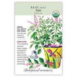 Botanical Interests seed packet for Tulsi Holy Basil, USDA Organic, illustrated with pink-flowered basil sprigs, a yellow dragonfly-patterned pot, and a tea infuser, with text noting it's an heirloom annual for full sun to part shade, sown after last frost.