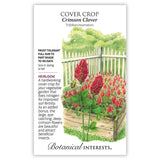 Botanical Interests seed packet for Crimson Clover cover crop, illustrated with tall spikes of deep crimson conical flowers and a bee in a raised wooden garden bed against a white picket fence, with text noting it's frost tolerant, heirloom, sown in spring or fall, and fixes nitrogen while attracting beneficial insects.