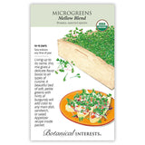 Seed packet for Mellow Blend Microgreens (Brassica, USDA Organic) illustrated with a wooden tray of dense green sprouts tinged with burgundy and a plated appetizer garnished with the greens, alongside text noting 10–15 day germination, indoor sowing, and an included recipe.