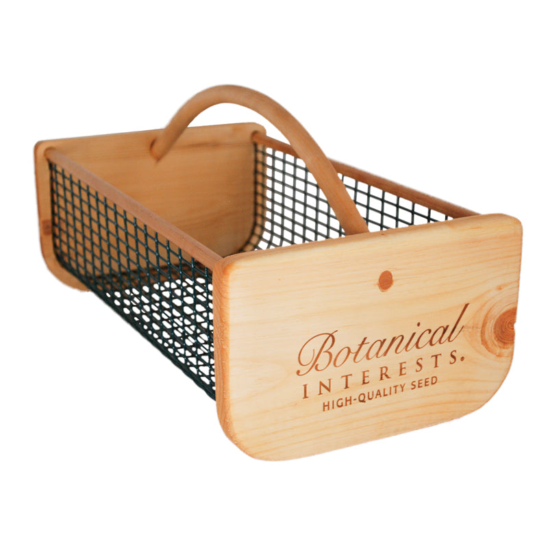 Wooden seed storage harvest basket with metal wire mesh and 'Botanical Interests HIGH-QUALITY SEED' logo printed on the front, set against a white background