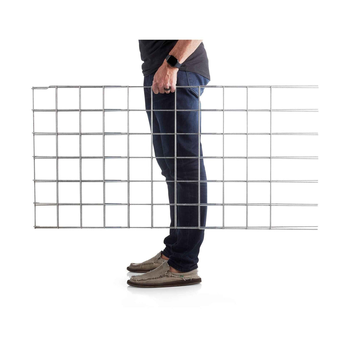 Side profile of a person carrying a flat, rectangular metal grid panel for Folding A-Frame Trellis Support For Plants.