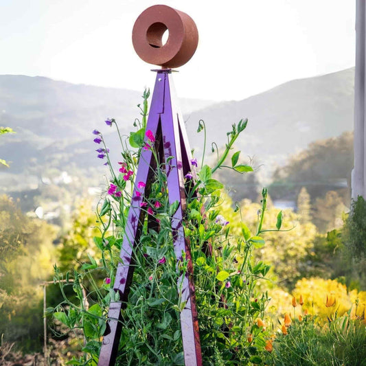 Aubergine purple three-legged metal Bird Cafe with Trellis surrounded by sweet pea vines and orange California poppies