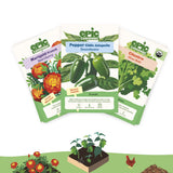 Three seed packet cards from Epic Gardening are fanned out against a white background, with illustrated garden plants, flowers, and a chicken along the bottom. The packets show varieties: Marigold French Red Cherry, Pepper Chile Jalapeño Soundwave, and Cilantro Spice Bolt.