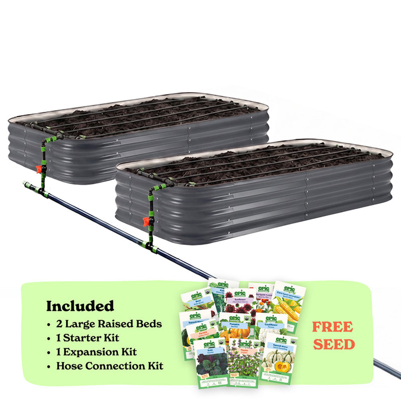 Two slate gray corrugated raised garden beds with soil inside, connected by a black hose of the epic irrigation system on a white background. A light green banner at the bottom lists included items: 2 15-inch tall large raised beds, 1 starter kit, 1 expansion kit, and hose connection kit, with a small seed packet collage and the words 'FREE SEED'.