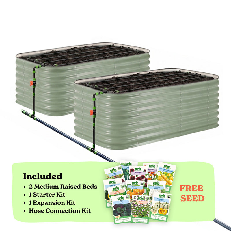 Two mist green corrugated raised garden beds with soil inside, connected by a black hose of the epic irrigation system on a white background. A light green banner at the bottom lists included items: 2 29-inch tall medium raised beds, 1 starter kit, 1 expansion kit, and hose connection kit, with a small seed packet collage and the words 'FREE SEED'.