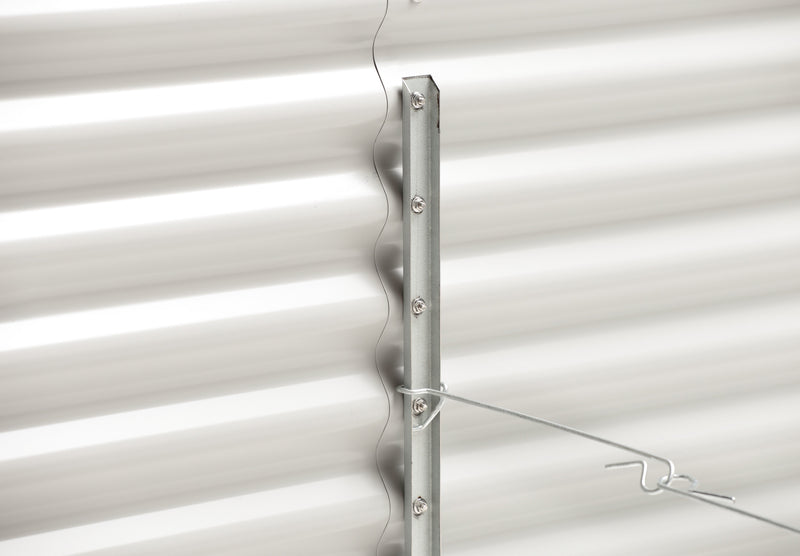 Metal bracket attached to a white corrugated metal wall