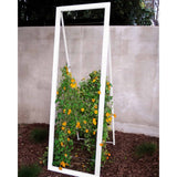 White metal frame A-frame Mira Garden Trellis with black-eyed Susan vines climbing up the grid wire, positioned in front of a concrete wall