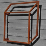 Zinc cubic metal Pablo Wall Trellis mounted on a horizontal wood panel wall, throwing geometric shadows