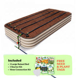 A raised garden bed in light clay color filled with soil, shown with drip irrigation tubing laid across the top. A light green promotional banner at the bottom lists included items: 1 15-inch tall large raised bed, 1 starter kit, and hose connection kit, with a small image of seed packets and the text 'Free Seed & Plant Tags'.