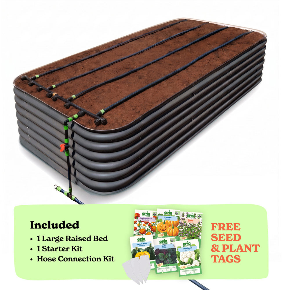 A 29-inch large raised garden bed in slate gray color filled with soil, shown with drip irrigation tubing laid across the top. A light green promotional banner at the bottom lists included items: 1 large raised bed, 1 starter kit, and hose connection kit, with a small image of seed packets and the text 'Free Seed & Plant Tags'.