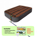 A raised garden bed in slate gray color filled with soil, shown with drip irrigation tubing laid across the top. A light green promotional banner at the bottom lists included items: 1 15-inch tall medium raised bed, 1 starter kit, and hose connection kit, with a small image of seed packets and the text 'Free Seed & Plant Tags'.