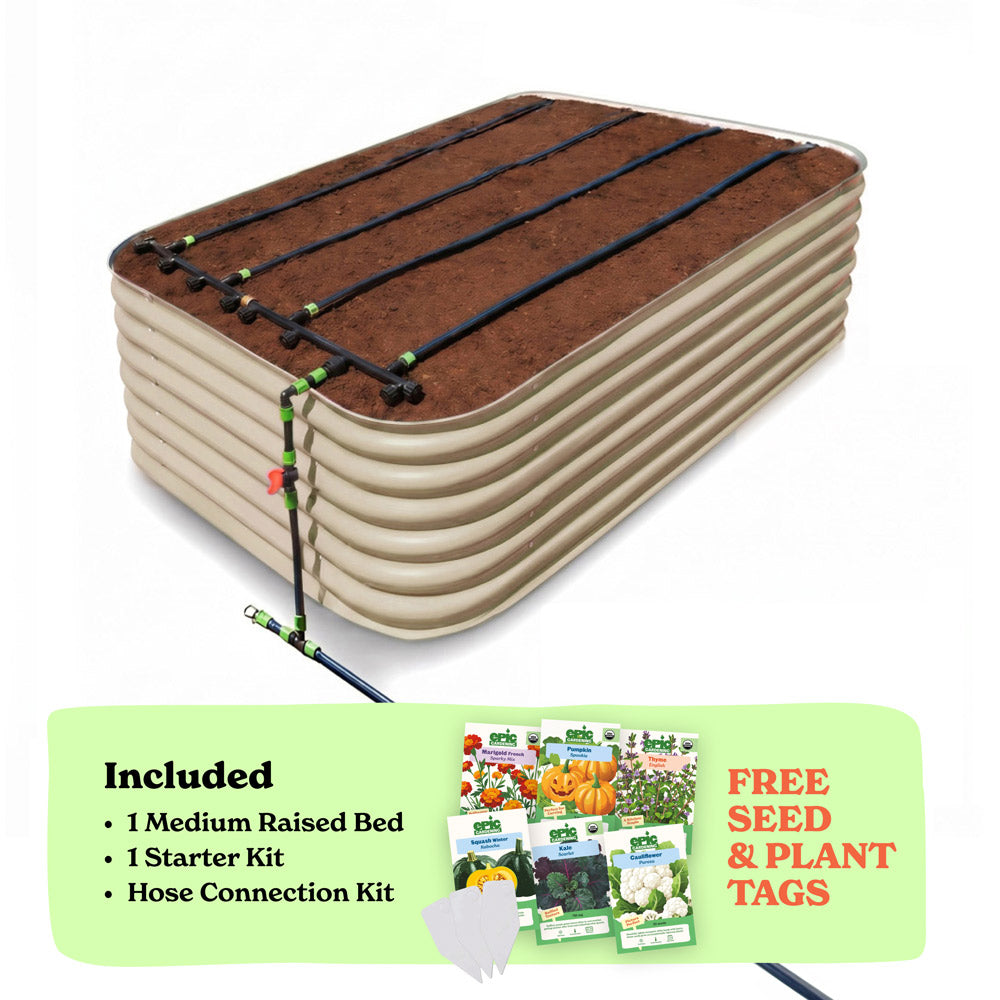 A raised garden bed in light clay color filled with soil, shown with drip irrigation tubing laid across the top. A light green promotional banner at the bottom lists included items: 1 29-inch tall medium raised bed, 1 starter kit, and hose connection kit, with a small image of seed packets and the text 'Free Seed & Plant Tags'.