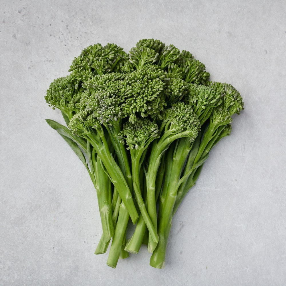 A bunch of Aspabroc Broccolini set on a flat gray surface