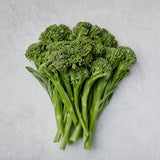 A bunch of Aspabroc Broccolini set on a flat gray surface