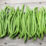 Freshly harvested long green bean pods arranged side by side on a rustic wooden surface