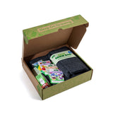 Open cardboard box of the "Buzz Bloom Epic Garden in a Box" containing a grow bag and seed packets with 'Keep On Growing' text.