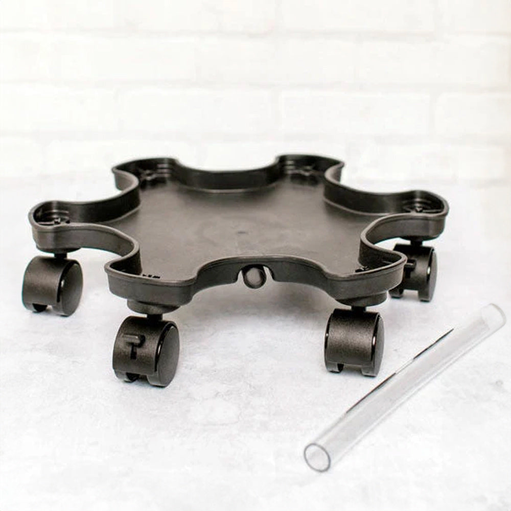 Black star-shaped plastic planter mover base with five scalloped indents and locking caster wheels at each point, shown beside a clear plastic support rod on a light surface.