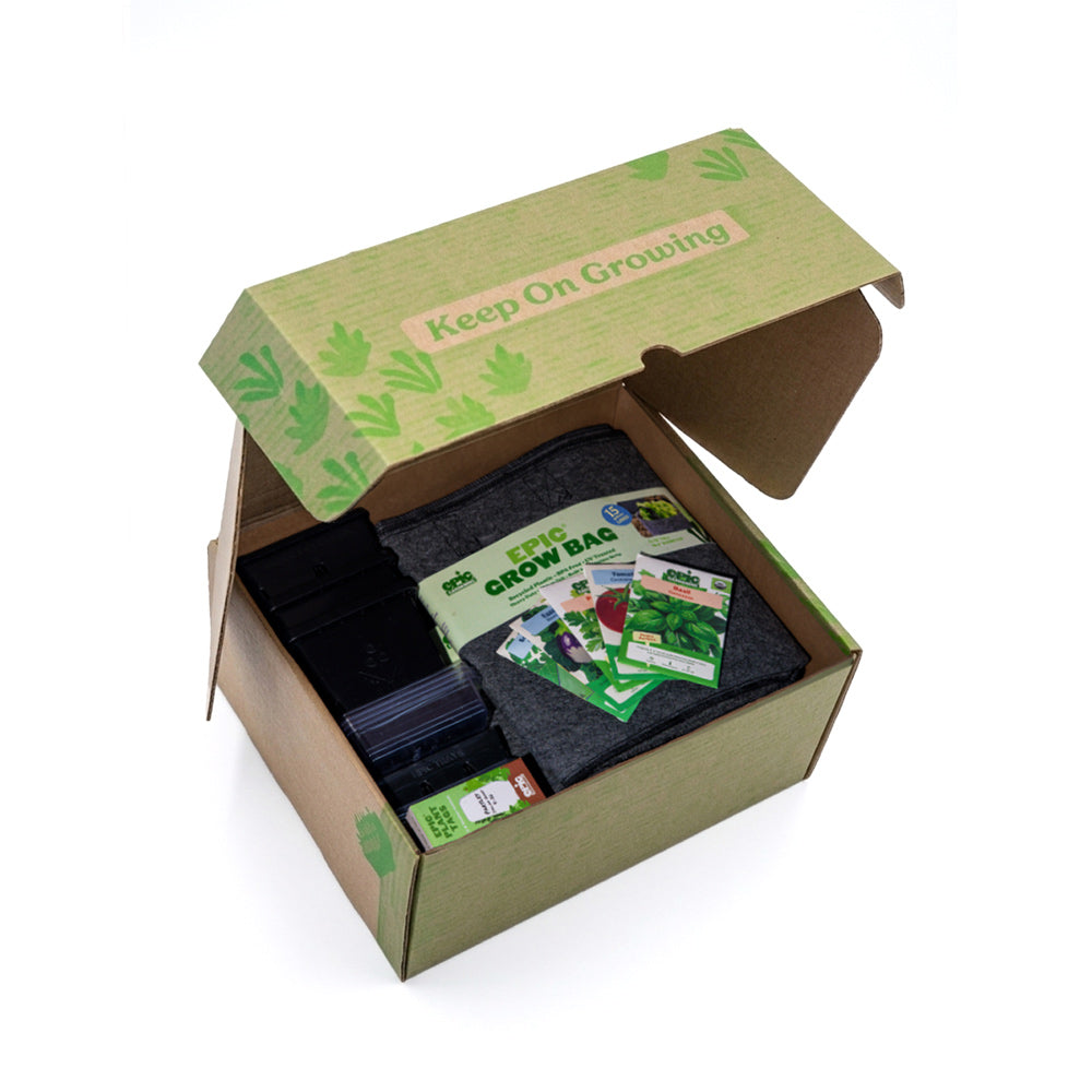 Open cardboard box of the "Little Italy Epic Garden in a Box" containing a grow bag and seed packets with 'Keep On Growing' text.