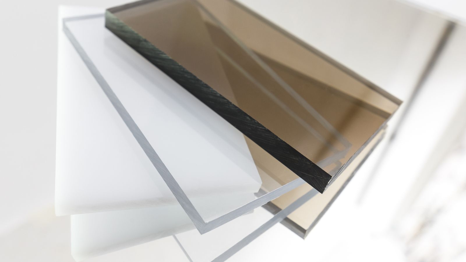 A close-up shot of a small pile of various colored and transparent Polycarbonate sheets