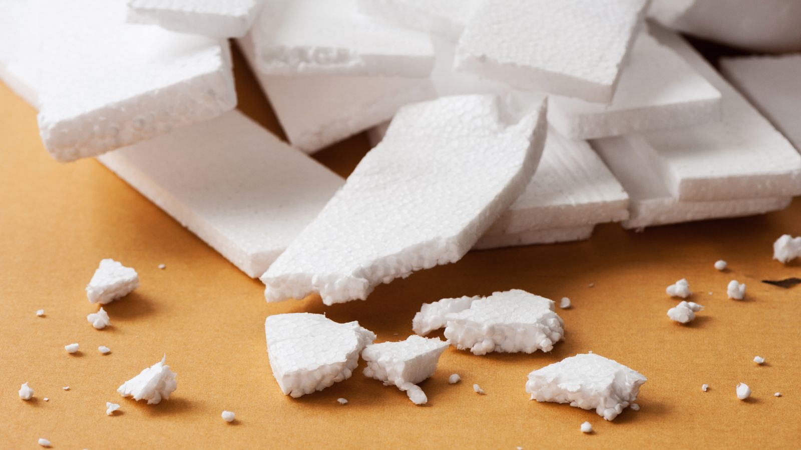 A close-up shot of a small composition of white synthetic materials called Polystyrene, some of which are broken down, all placed in a well lit area