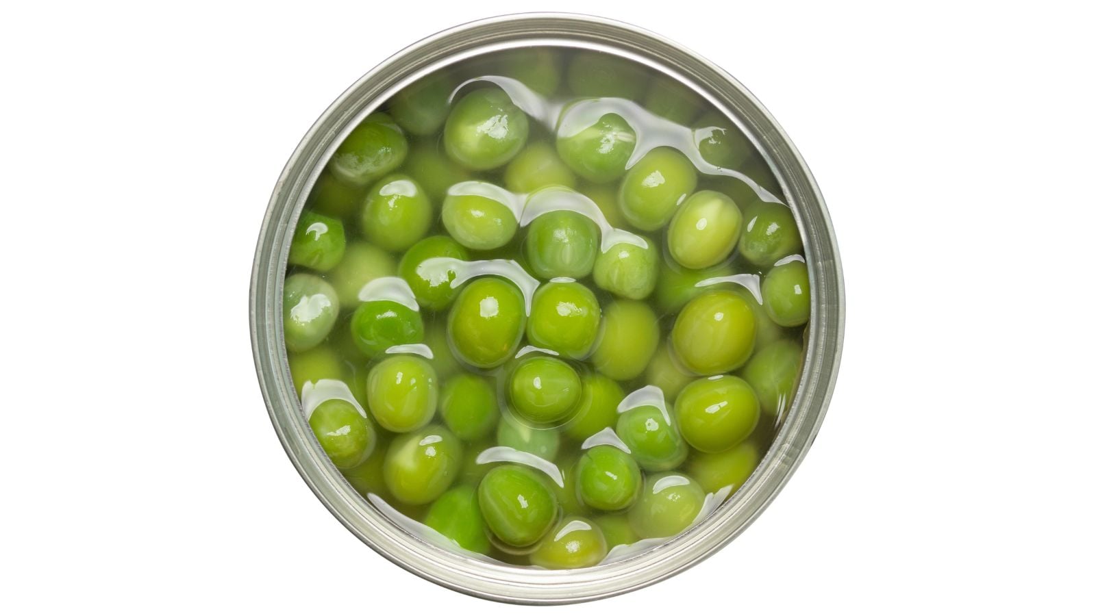 Round green seeds soaked in liquid ready for canning, appearing to be placed on a pure white surface