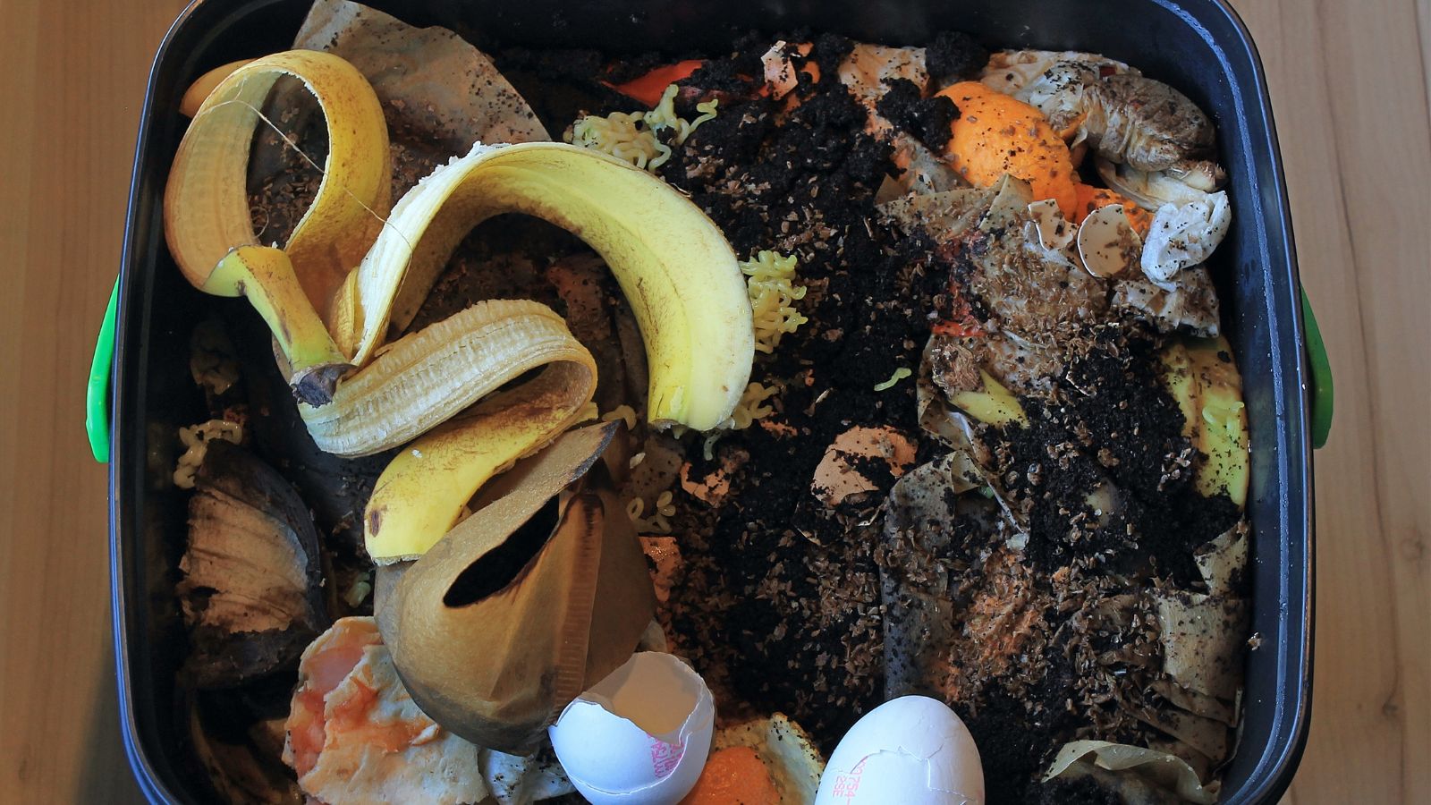 A close-up and overhead shot of a full bucket of food scraps, placed in a well lit area