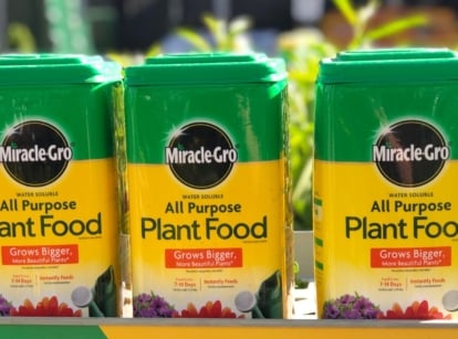A close-up shot of several containers of an organic brand of plant food, showcasing miracle gro organic gardening