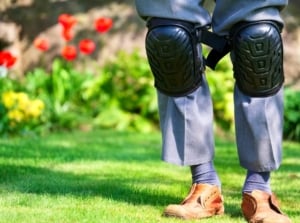 Knee pads worn by elderly old man in garden