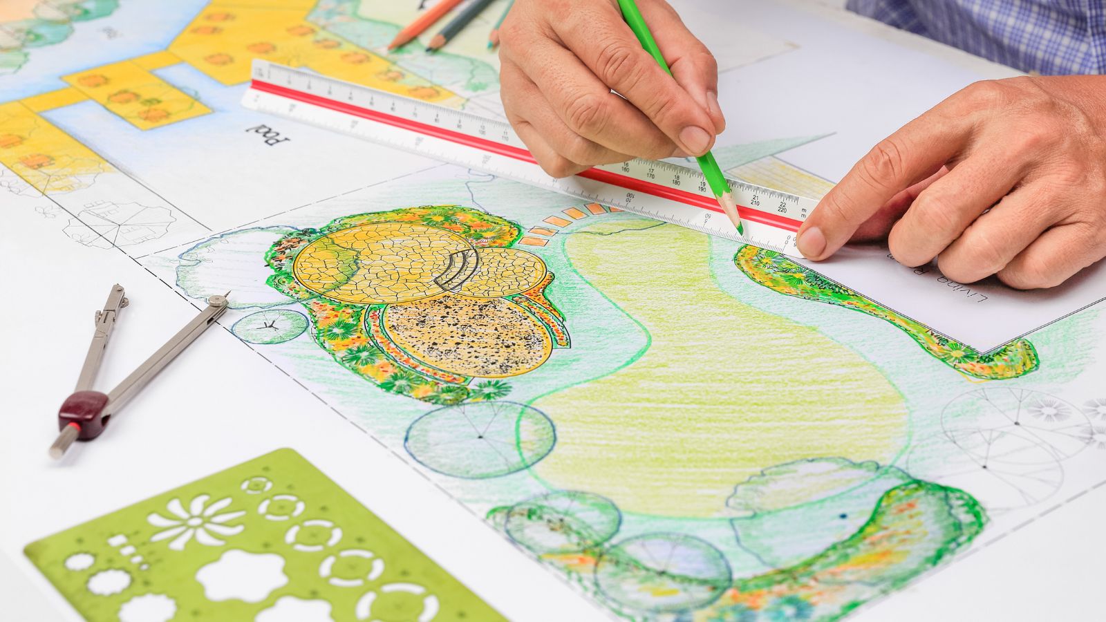 A shot of a person in the process of drawing a landscape design concept