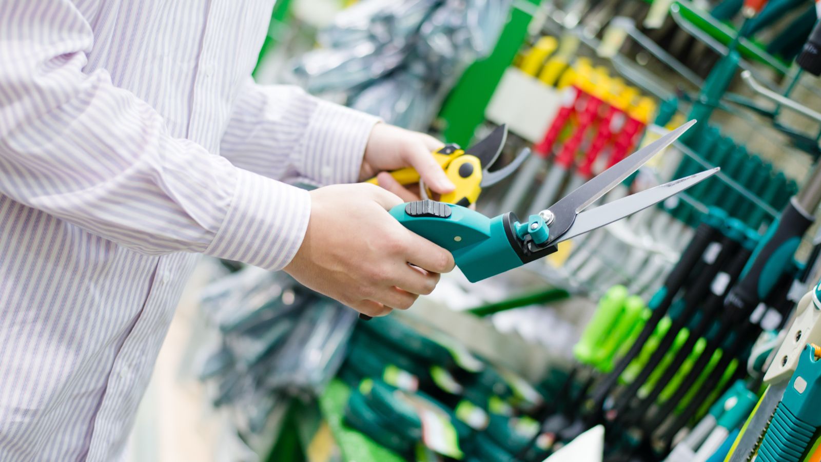 A close-up shot of a person in the process of selecting and purchasing gardening tools