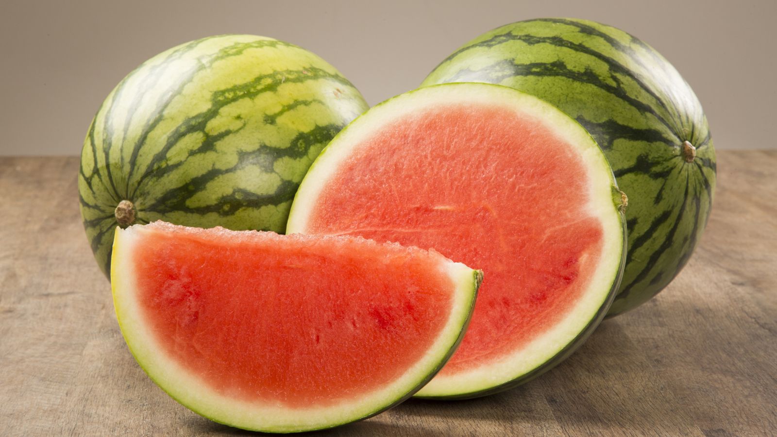 A close-up shot of a ripe, round and seedless crops placed on a wooden surface in a well lit area indoors
