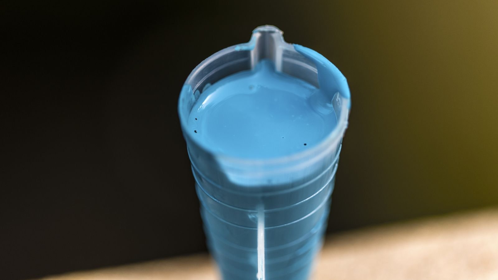 A close-up and overhead shot of a small vial filled with blue thick liquid of a Copper Fungicide