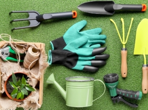 A flat lay shot of Luxury gardening gifts appearing to include gloves, trowels and other tools used for gardening, placed on a green fluffy surface
