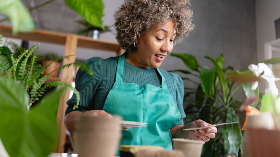 A mature woman choosing through slow germinate plants start January, appearing to look through different options to start indoors