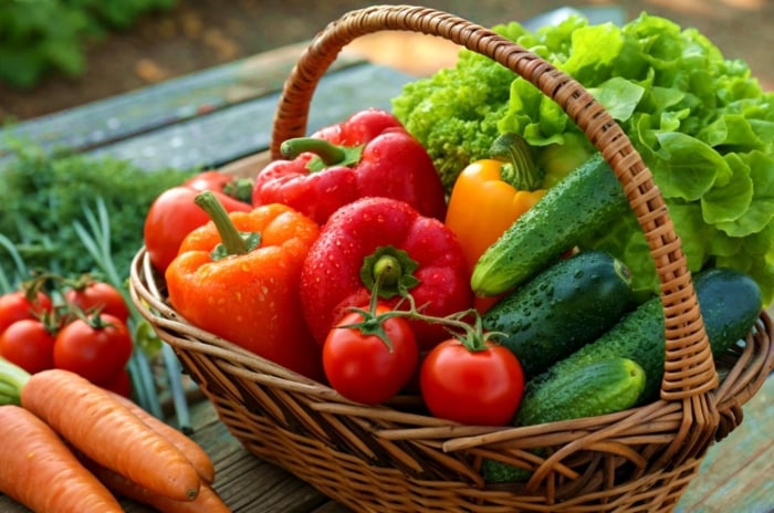 A close-up shot of a rustic wicker basket filled with freshly harvested crops, showcasing garden feed family