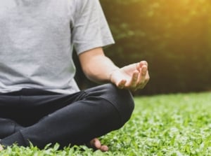 A close-up shot of a person in the process of relaxing and pondering, showcasing how to create a meditation garden